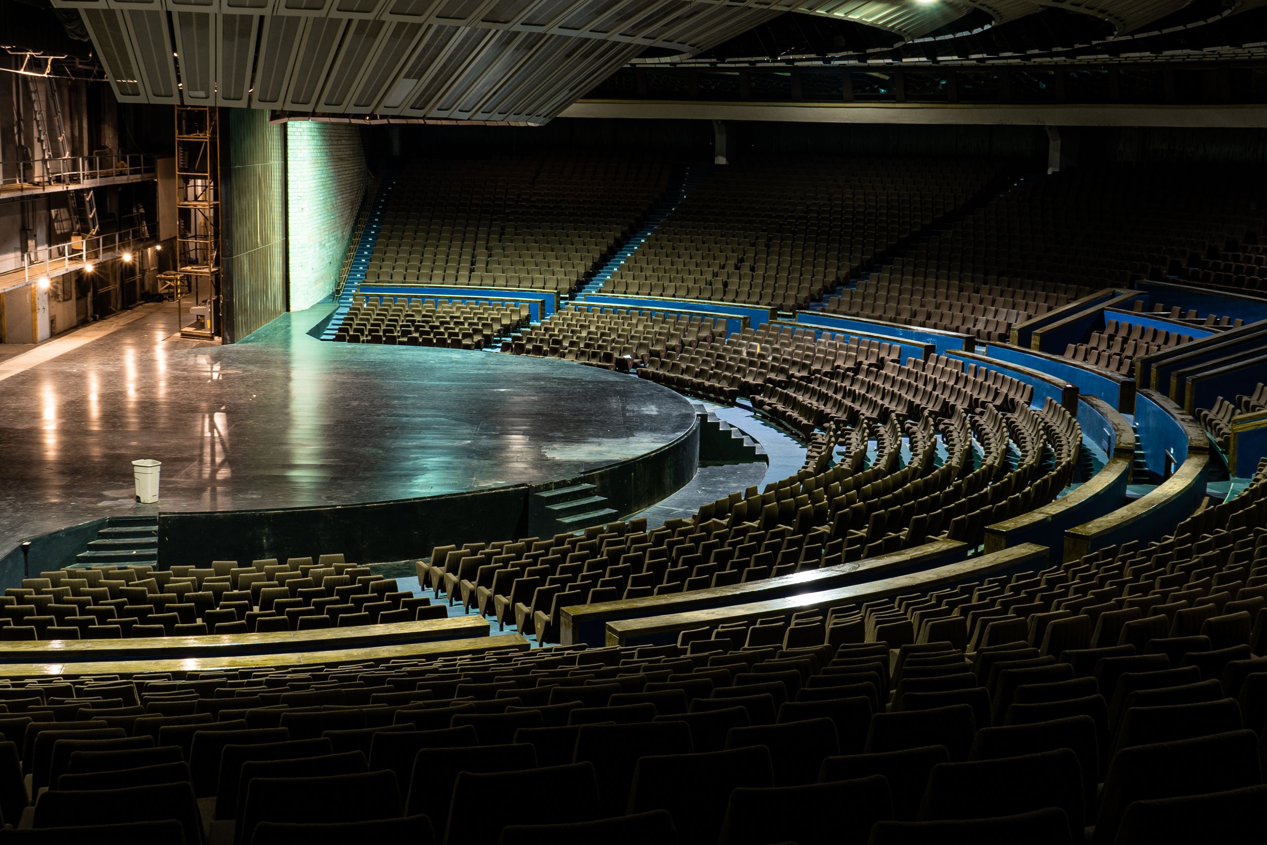 An empty auditorium with the stage and institutional machinery of performance still in place.